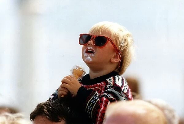 Two year old Craig Emmerson enjoys an ice cream whist watching an air display at