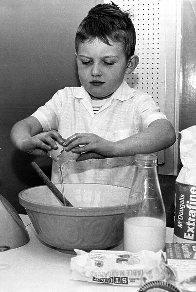 Six year old David Glass of Brighton pictured breaking eggs into a bowl to make a cake