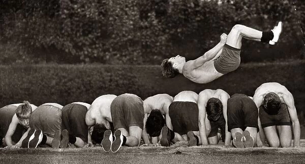 Fifteen year old Ronnie Laing leaping over a dozen of his colleagues in training for next