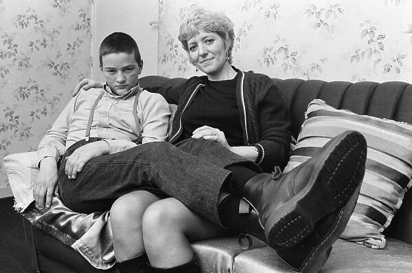 Fifteen year old skinhead Chris Harward poses at home with his mother Joan at their flat