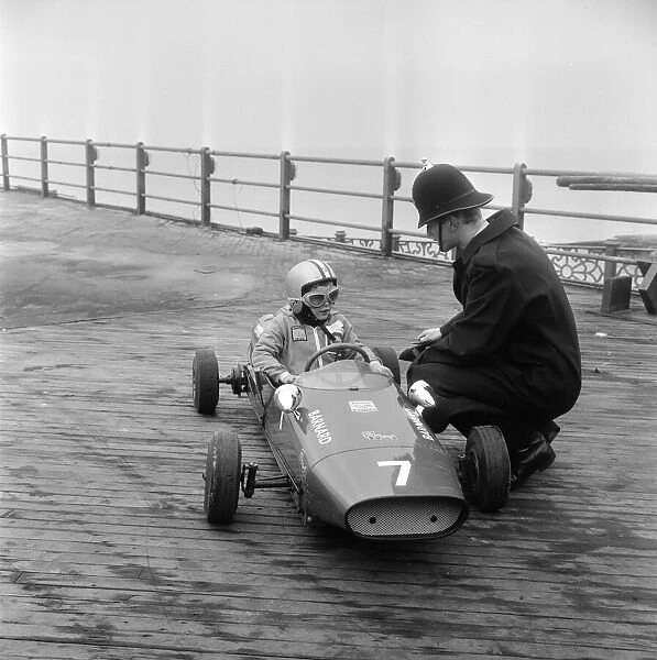 Eight year old Thomas Barnard in his racing car, speaking to a policeman on the West Pier
