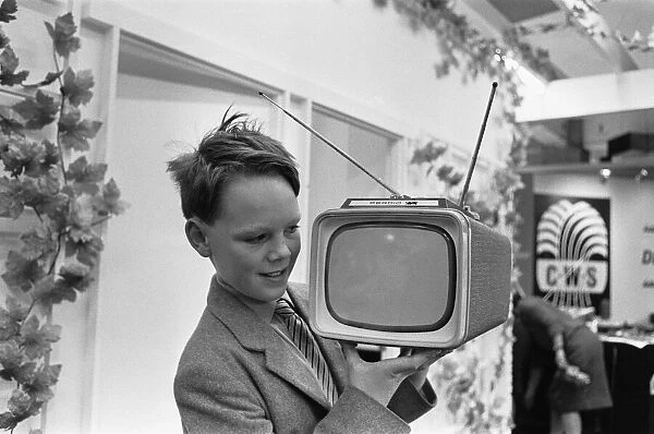 A young boy demonstrating the new Perdio Portorama portable television receiver at