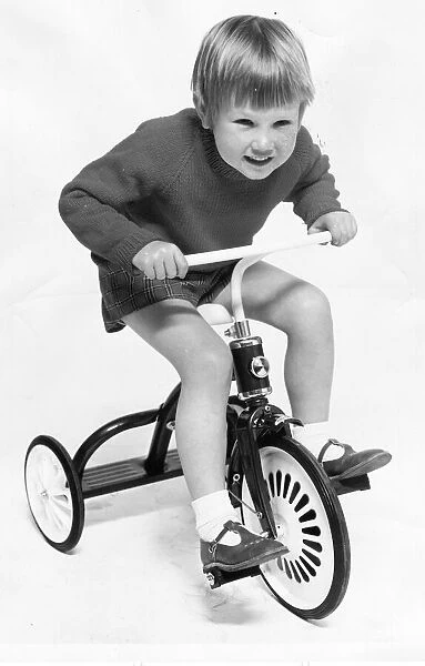 A young boy enjoying a ride on his tricycle