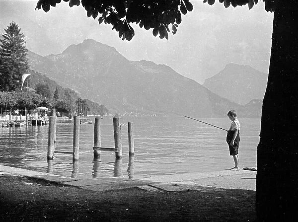 Young boy fishing near to the Swiss village of Seelisburg. August 1936