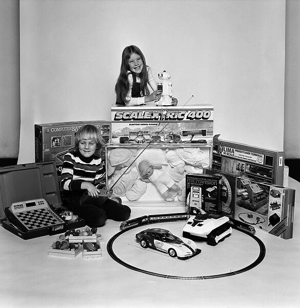 A young boy and girl with a selection of childrens toys for Christmas. December 1980