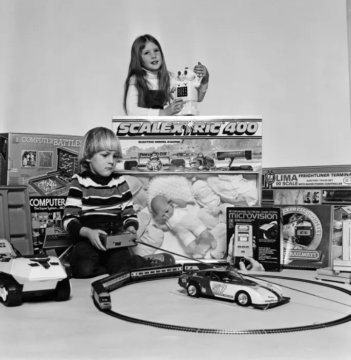 Framed Print : A young boy and girl with a selection of childrens toys for Christmas. December 1980
