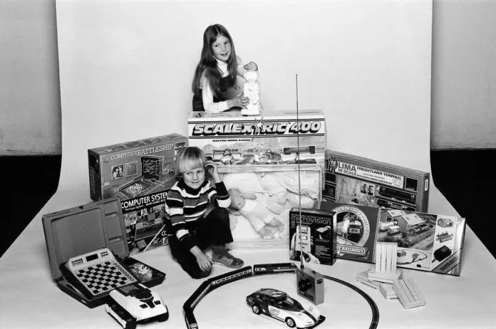 Framed Print : A young boy and girl with a selection of childrens toys for Christmas. December 1980