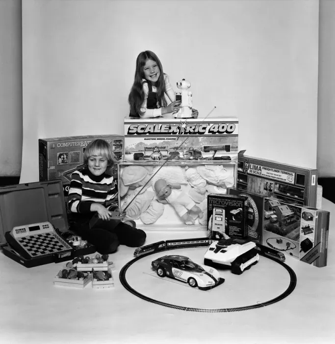 Framed Print : A young boy and girl with a selection of childrens toys for Christmas. December 1980
