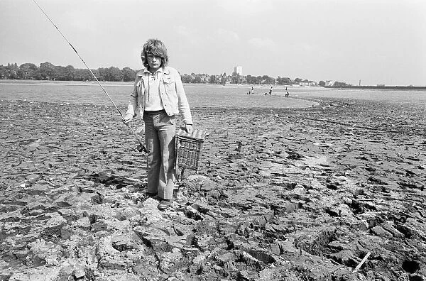 Young boy goes for a spot of fishing at dried out Edgbaston reservoir in Birmingham
