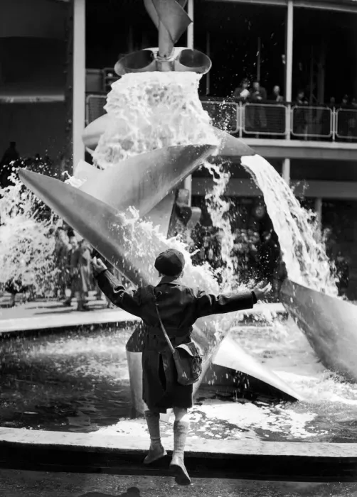 Framed Print : A young boy jumps for joy whilst looking at a modern water feature at the Festival of Framed Print : A young boy jumps for joy whilst looking at a modern water feature at the Festival of