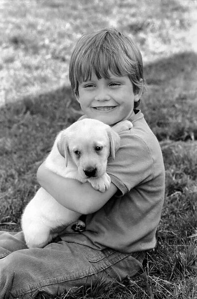 A young boy with a labrador puppy at the Frant Kennels in Hildenborough near Tonbridge