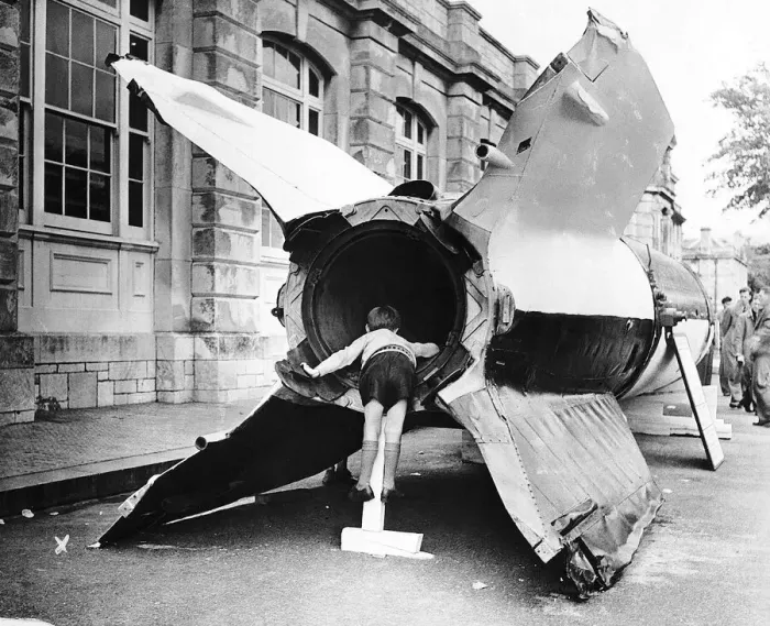 Framed Print : A young boy looks into the rocket motor of a captured V2 flying bomb during open day Framed Print : A young boy looks into the rocket motor of a captured V2 flying bomb during open day
