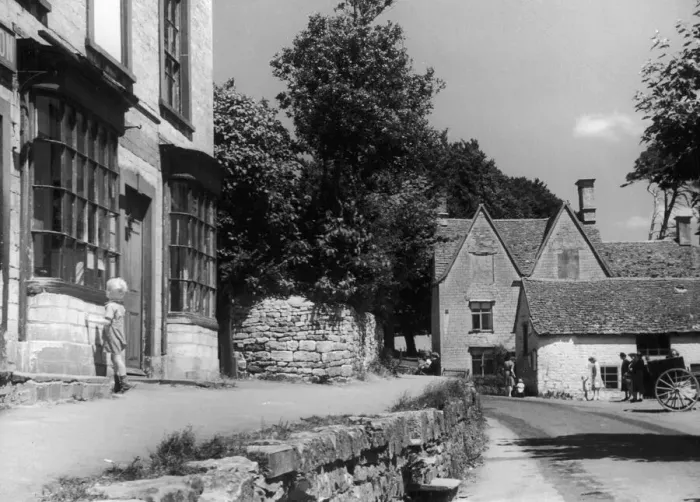 Framed Print : Young boy peering theough a shop window in the Cotswold village of Uley near Dursley in Framed Print : Young boy peering theough a shop window in the Cotswold village of Uley near Dursley in