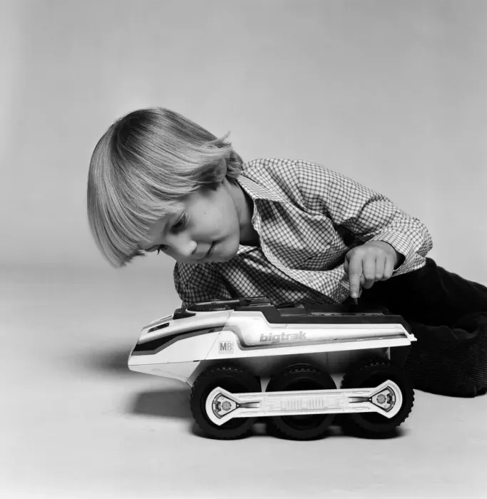 Framed Print : A young boy playing with a Big Trak toy, a programmable electric vehicle created by Framed Print : A young boy playing with a Big Trak toy, a programmable electric vehicle created by