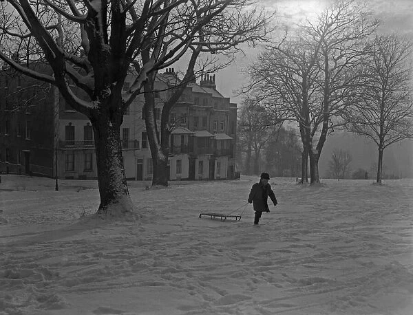 A young boy pulls his sledge up Sion Hill, Clifton, Bristol. 1st January 1962