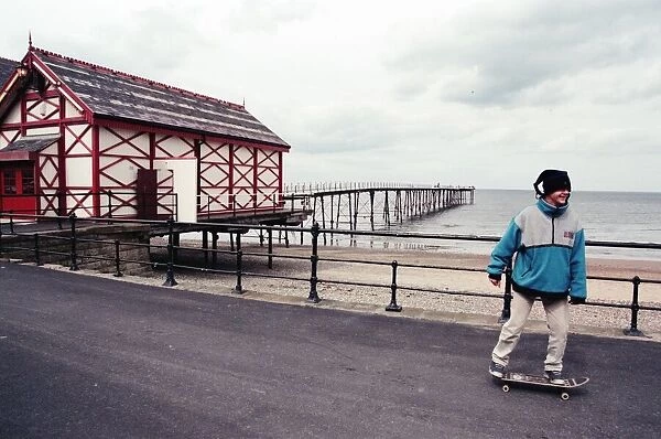 A young boy skateboarding past Saltburn pier, North Yorkshire. 9th May 1996