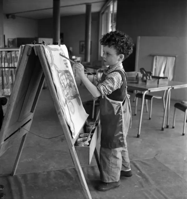 Framed Print : Young boy standing by his easel during an art class at Cookham Nursery School Framed Print : Young boy standing by his easel during an art class at Cookham Nursery School