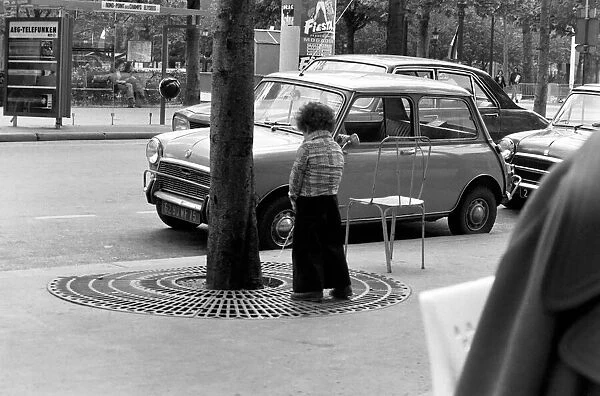 Young boy urinates outside a cafe on the Champs Elysees in Paris, France