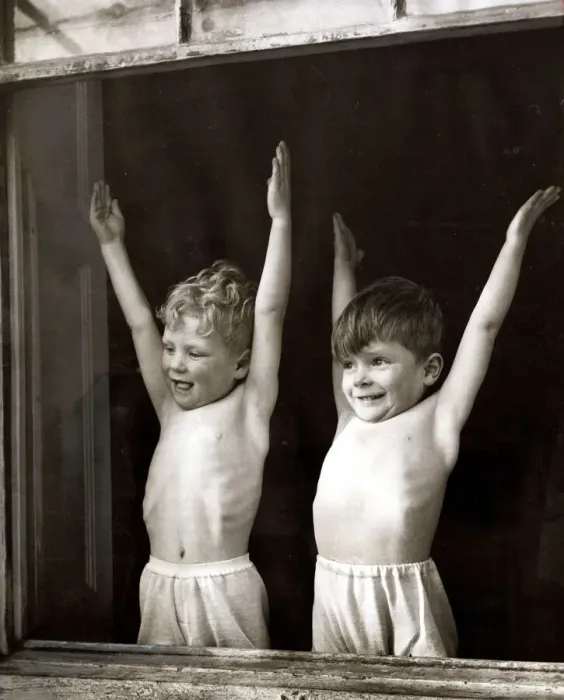 Framed Print : Two young boys doing stretching and breathing exercises in front of an open window