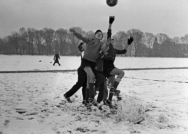 Young boys playing football in the snow, Cambridge January 1960
