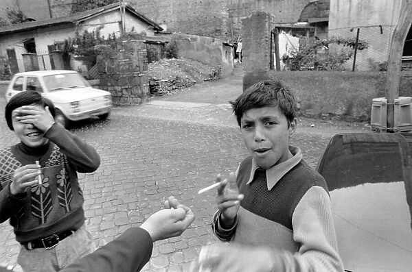 Two young boys on the streets smoking cigarettes in a poor suburb on the outskirts of
