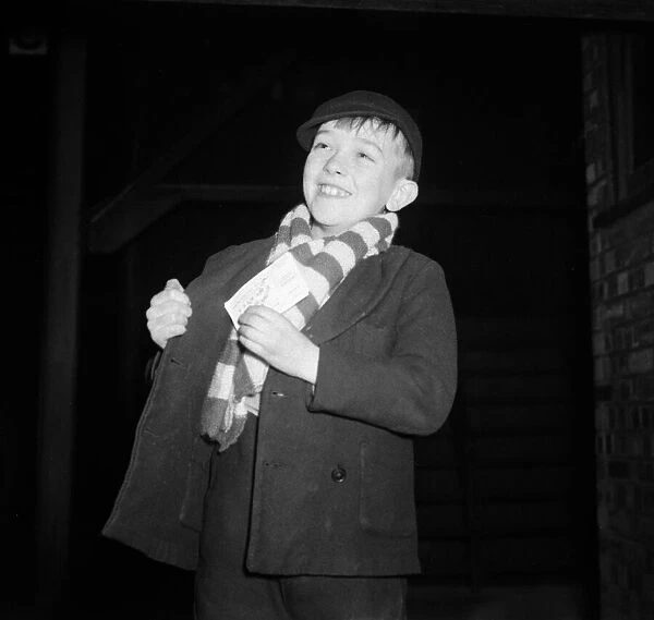 A young Brentford supporter smiles after receiving his ticket for the cup tie against