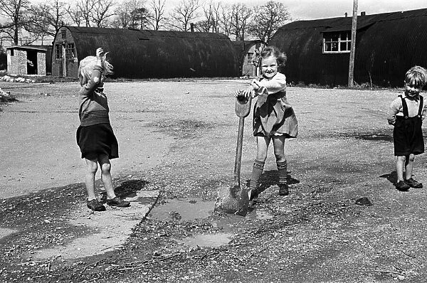 Three young children playing in a deserted airfield. May 1947