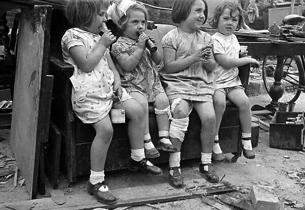Young children surrounded by bomb damage on St Marys Road, Edmonton July 1944