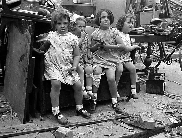 Young children surrounded by bomb damage on St Marys Road, Edmonton July 1944