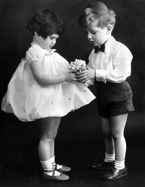Young couple exchanging flowers. 13th Feb 1959