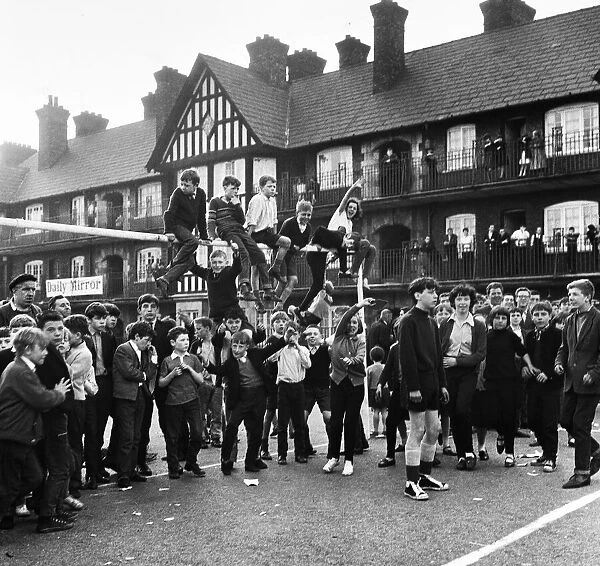 Young football fans sits on top of the crossbar following the conclusion of the Eldon