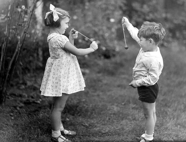 Young girl and boy playing conkers. circa 1945