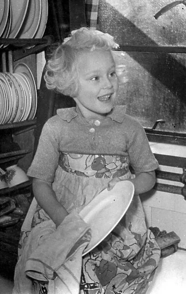 Young girl helping out a home by doing the washing up Circa 1945 P044422
