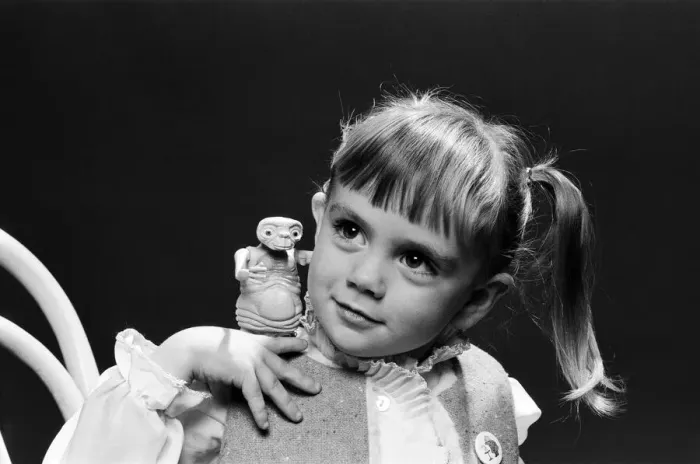 Framed Print : A young girl holding an E. T. from the film E. T. the Extra-Terrestrial. 5th December 1982