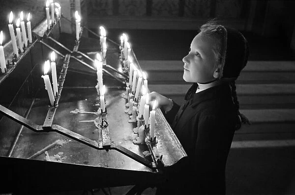 A young girl looking at candles at Westminster Cathedral, London, October 1946