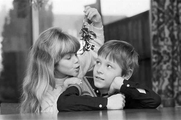 A young Girl with mistletoe attempts to kiss a young lad. 23rd December 1985