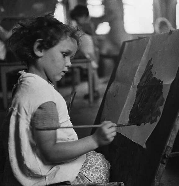 A young girl painting a picture at London County Council