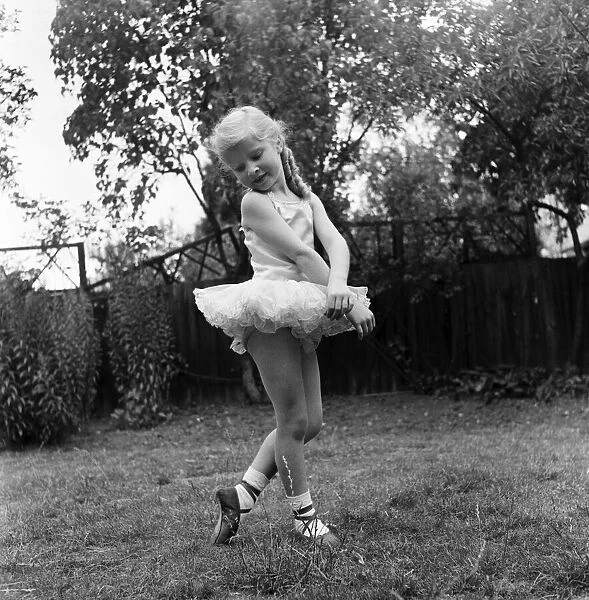 Young girl Penny Brown practising her Ballet dancing wearing a tutu in the back garden
