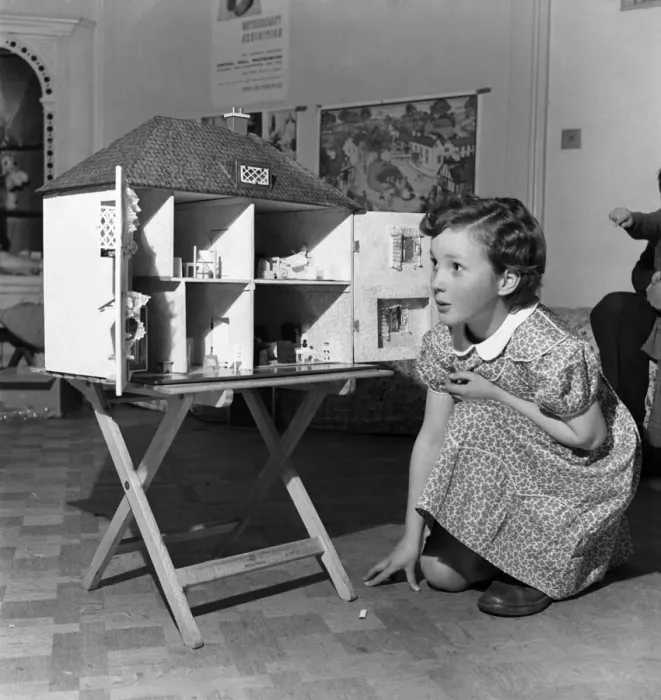 Framed Print : Young girl playing with dolls house. October 1952 C4969