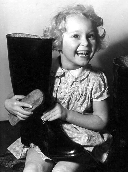 Young girl polishing a pair of wellington boots Circa 1945 P044462