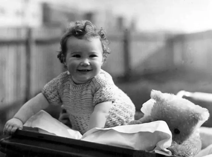 Framed Print : Young girl in her pram with her favourite teddy bear Circa 1945 P044429