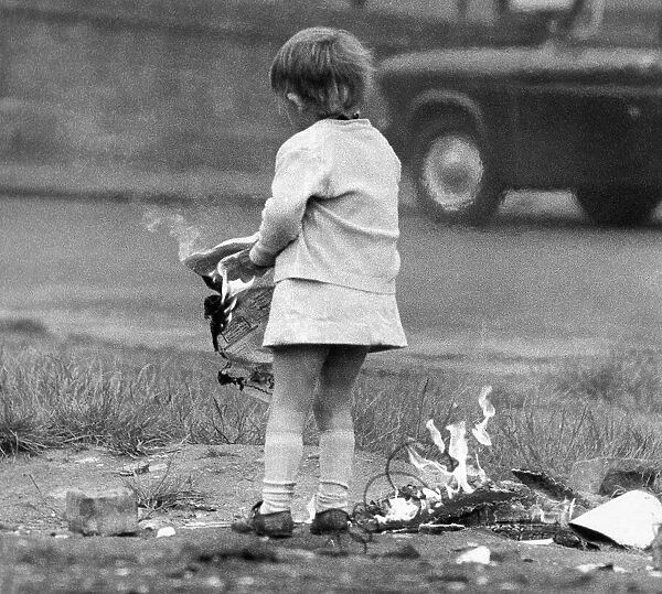A young girl risks injury playing with fire on wasteland November 1972