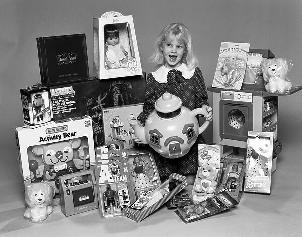 A young girl with a selection of childrens toys for Christmas. 6th December 1984