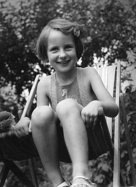 Young girl sitting in a deck chair in the back garden Circa 1945 P044441