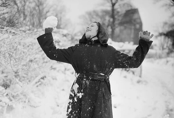 A young girl of St. Lythams near Cardiff, Wales, takes part in a snowball fight with