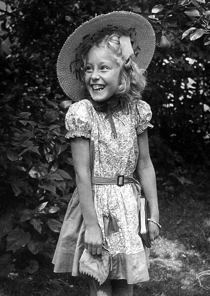 Young girl standing in the back garden wearing a flowery dress
