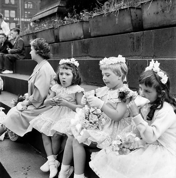 Young girls dressed in their sunday finest enjoy a sandwich after taking part in