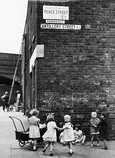 Young girls playing mums with their dolls and toy prams on the corner of Peace Street
