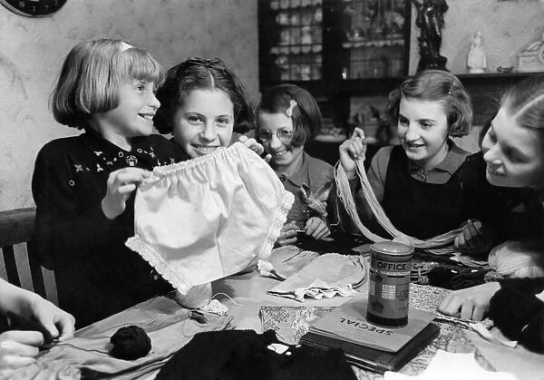 Young girls showing off one of six pairs of knickers that they made from an old night
