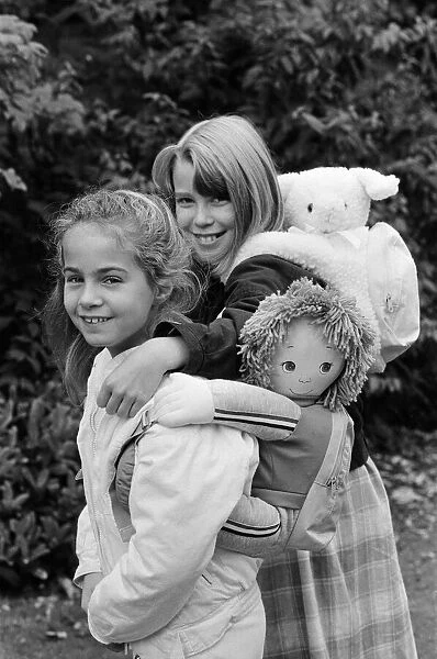 Two young girls wearing soft toy rucksacks. 21st October 1986